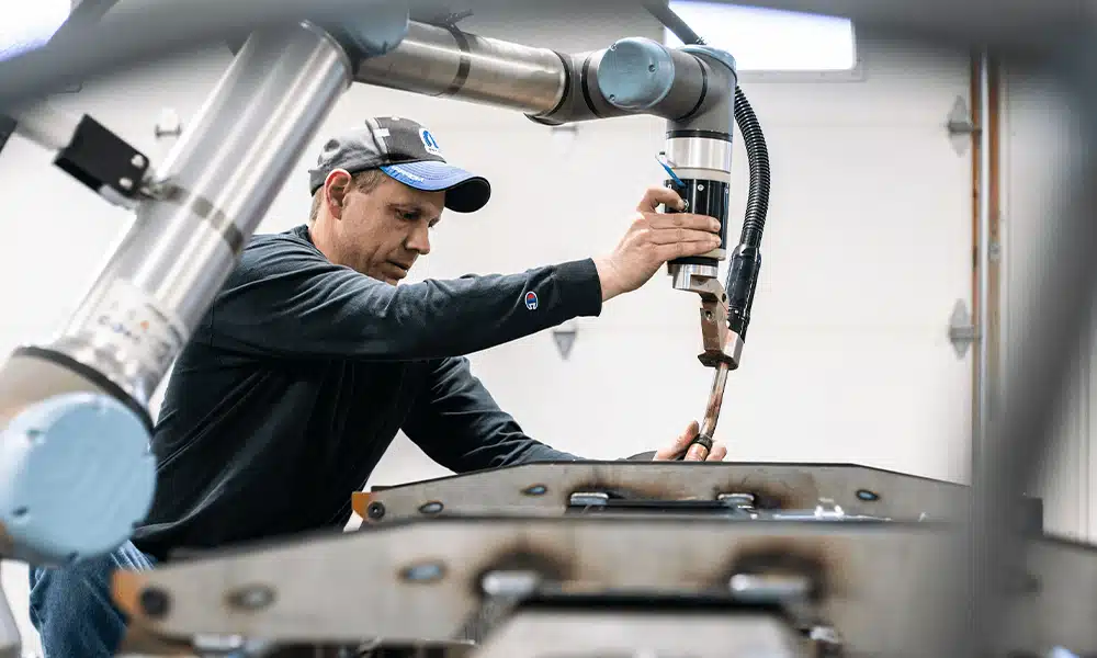 Engineer adjusting a robotic arm for precision welding
